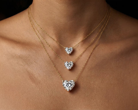 Three Eternal Heart diamond pendants in graduated sizes worn layered at the neck