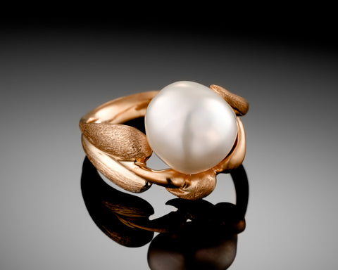 Autumn ring in rose gold, a white keshi pearl held between two gold leaves