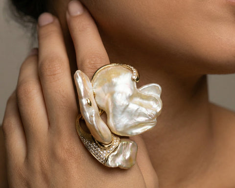 Pearl ring with gold accents on a hand