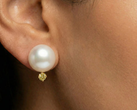 Pearl earring with gold accent on a person's ear