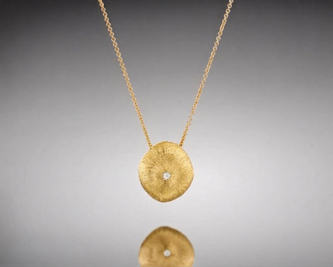 Arthropod necklace, 11 x 12 mm, in yellow gold, a larger hollow brushed nugget with a diamond at the center on a rolo chain