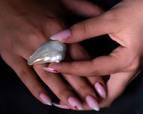The Burst ring worn on the hand, showing the scale of the Soufflé pearl