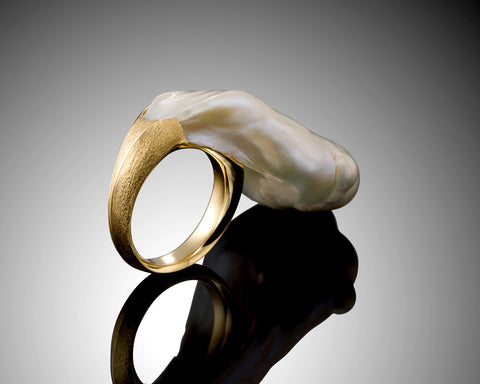 Side view of the Burst ring showing the gold band widening to meet the pearl