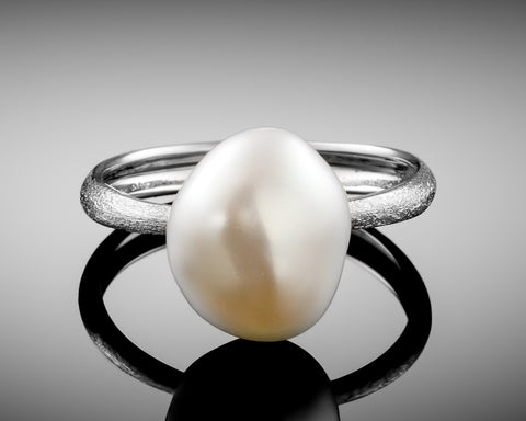Century ring in white gold standing upright, showing the pearl from the side