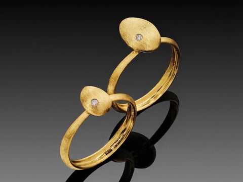 Small and large Cleaner Wrasse rings in 14K yellow gold, hollow brushed fish forms each with a bezel set diamond, shown side by side