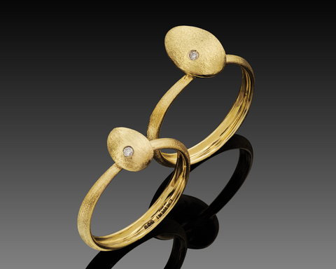 Small and large Cleaner Wrasse rings in 14K yellow gold, hollow brushed fish forms each with a bezel set diamond, shown side by side