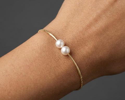 Cross Paths pearl bracelet worn on the wrist