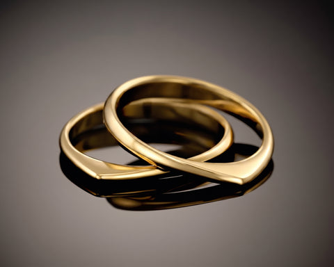Two twisted gold plated rings, one resting inside the other
