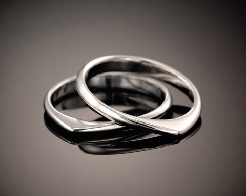 Two twisted silver rings, one resting inside the other