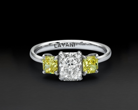 Three stone ring in 18K white gold, a radiant white diamond between two fancy yellow radiants