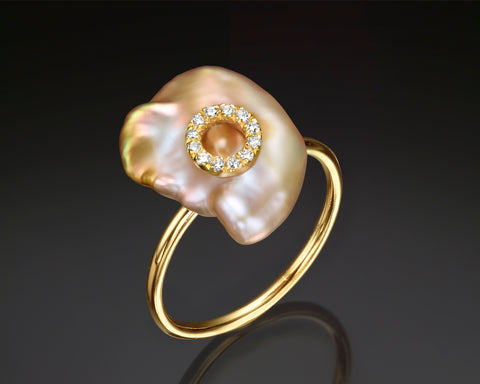 Nikea ring in yellow gold standing upright, showing the keshi pearl and the polished open band from the side