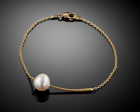 Nova bracelet in yellow gold, a single Keshi pearl on a curved brushed bar