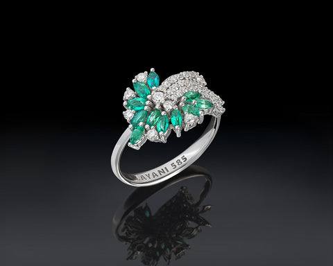 white gold ring with emerald green gemstones on a black background