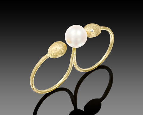 Porpoise two-finger ring in yellow gold, two open brushed bands ending in diamond nuggets with a white freshwater pearl rising between them