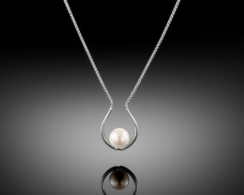 Pray necklace in white gold with a pearl inside the horseshoe