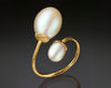 Gold open ring turning to show two white drop pearls of different sizes
