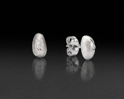 Requiem stud earrings, 4.6 x 7.7 mm, in white gold with a diamond at the center