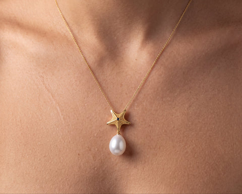 Starfish pendant with a white drop pearl worn at the neck