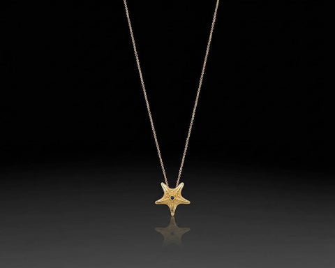 Starfish pendant in yellow gold with granulated texture and a small stone at the center