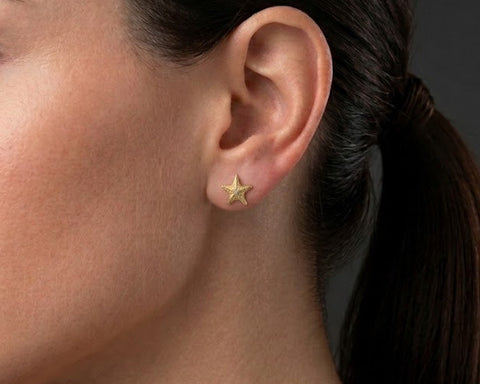 Starfish stud earring in yellow gold worn on the ear