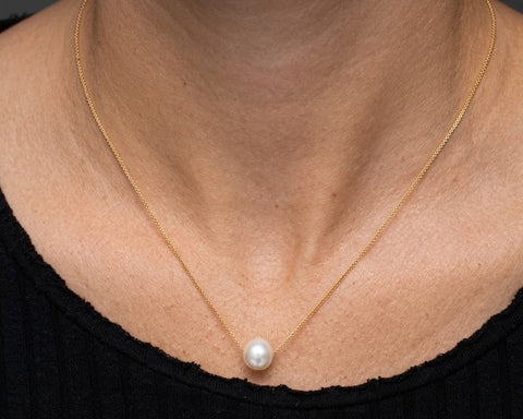 Sun floating pearl necklace worn at the base of the neck
