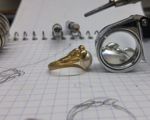 Side profile showing gold leaves pinned to a drilled Keshi pearl