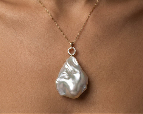 Gold necklace with a large Keshi baroque pearl pendant resting at the collarbone