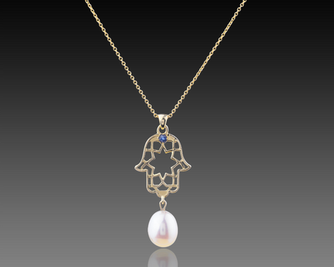 Yellow gold hamsa pendant with a sapphire at the center and a pearl below