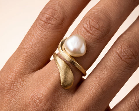 Woman wearing a handmade gold open ring with a Keshi pearl and brushed finish