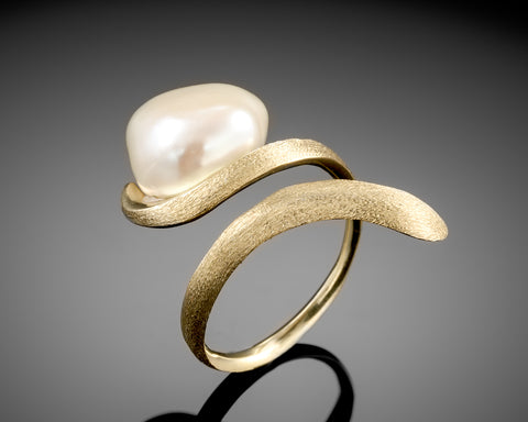 Side view of a brushed gold open ring with a white Keshi baroque pearl