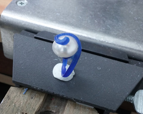 Blue wax carving of the spiral ring with the pearl held in position