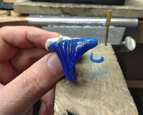 The blue wax model of the Mantle ring held in hand at the jeweler's bench