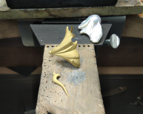 The raw gold of the Mantle ring before finishing, beside the Keshi pearl at the bench