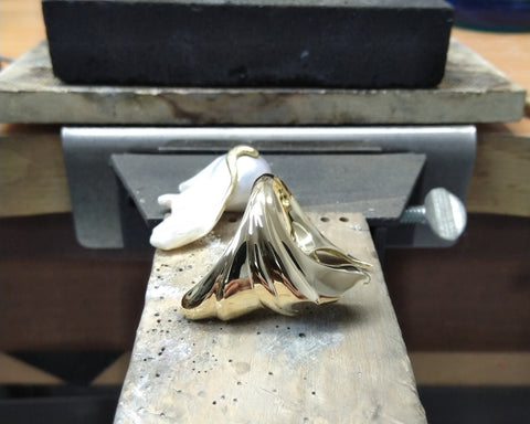 The gold of the Mantle ring after polishing to its matte finish, beside the Keshi pearl at the bench