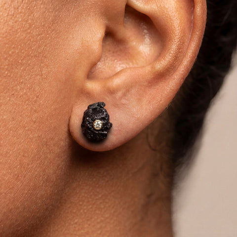 Close-up of black rough diamond with white diamond accent, Mist studs by LAYANI