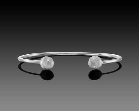 Yellowtail open bangle in white gold with a diamond nugget at each end