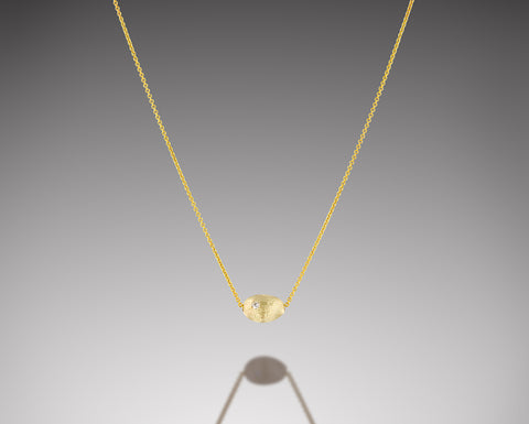 Bryozoa necklace in yellow gold, a single small brushed nugget with a diamond floating on a fine chain