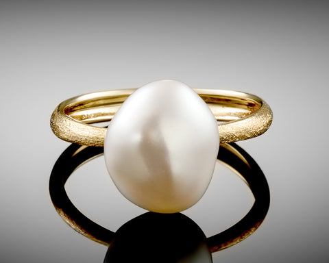 Century ring in yellow gold standing upright, showing the pearl from the side