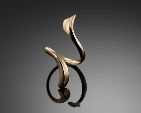 Open sculpted ring in gold plated silver, two ends rising off the band
