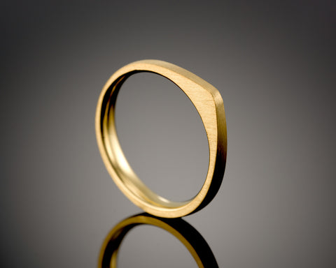 Tapered stacking ring in gold plated silver, wide at the top narrowing to the base