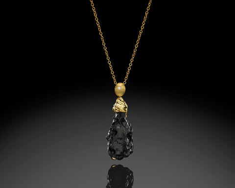 Handmade 18K gold pendant with a 32.5 carat natural black tektite and a brilliant cut diamond