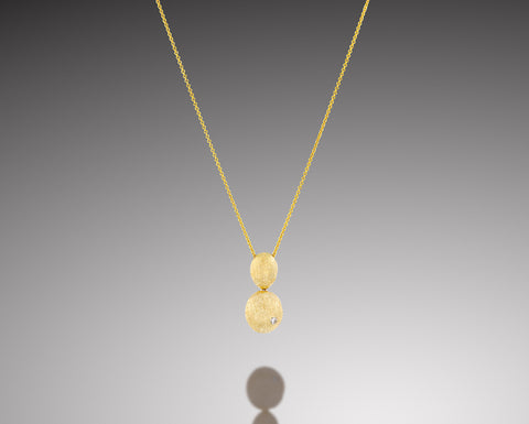 Sand Dollar pendant in yellow gold, two brushed hollow nuggets one above the other with a small diamond in the lower one