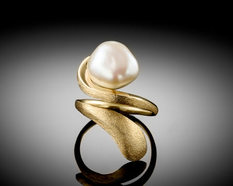Handmade 18K yellow gold open ring with a white Keshi baroque pearl held between two curved arms