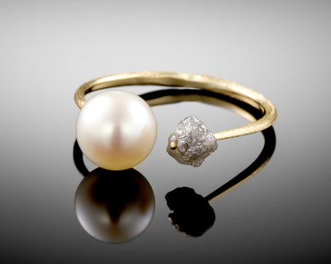 Stardust ring, raw grey diamond threaded through an open 14K yellow gold band beside an 8mm freshwater pearl, by LAYANI Fine Jewelry Jerusalem
